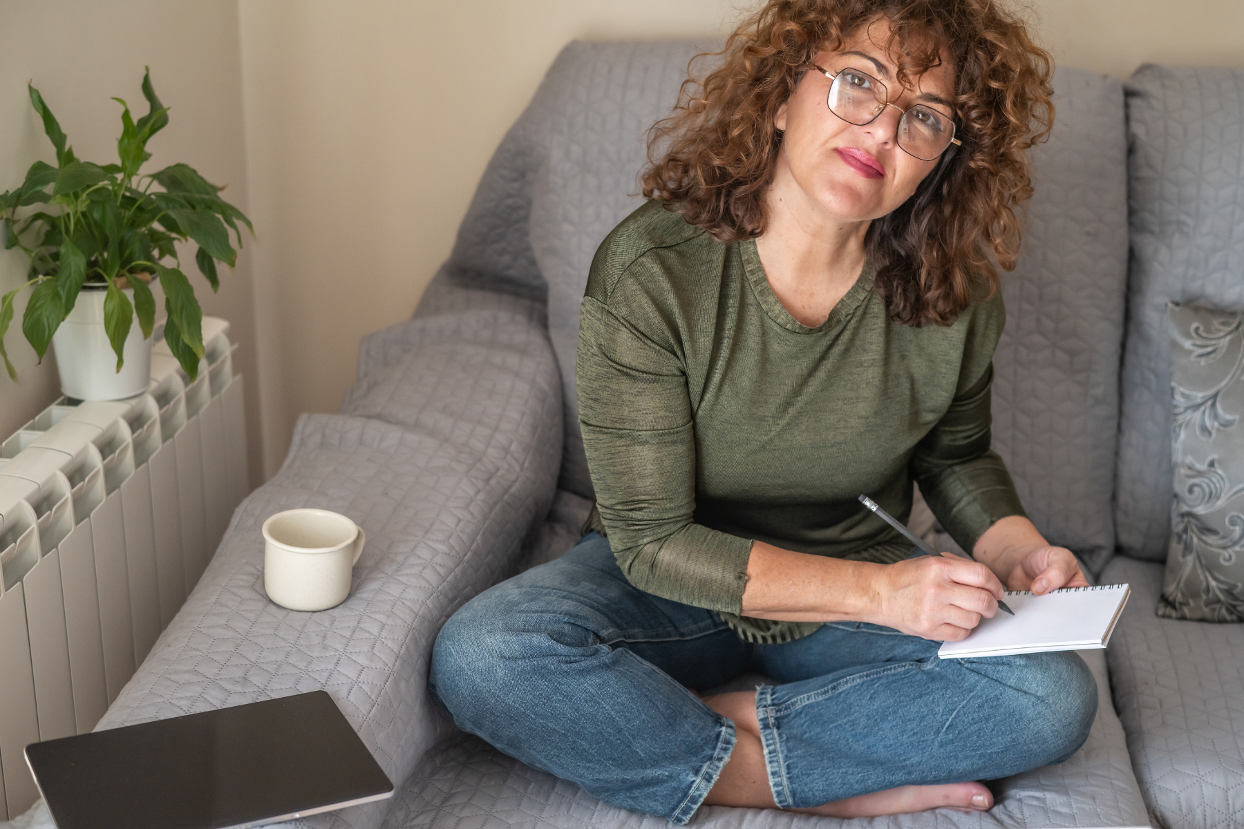 Woman sitting at home with a notebook, planning her day